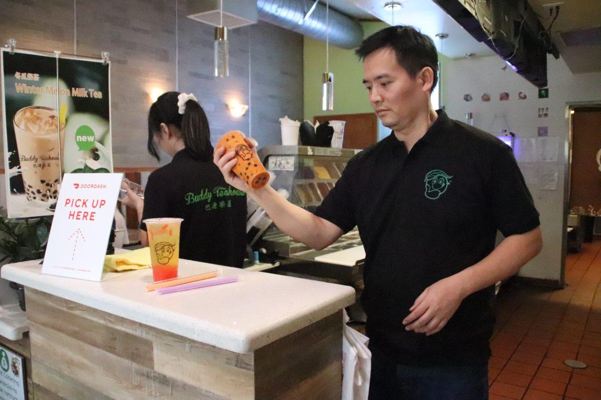 Buddy Teahouse owner Jay Tran shakes and serves a cup of Thai tea during the afternoon rush at his tea shop. 