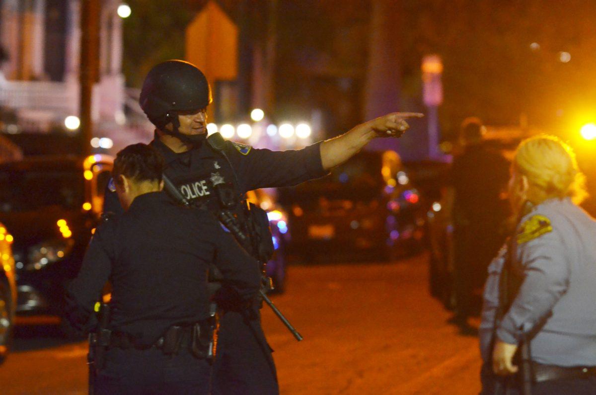 San Jose Police Department officers surround a house on Eighth Street, demanding that the suspects inside surrender. Mauricio La Plante/Spartan Daily