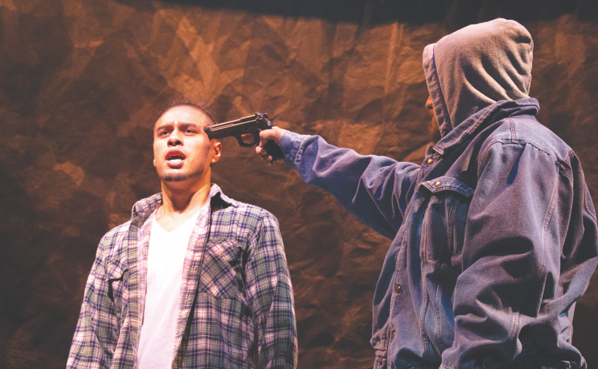 Alumnus David Martinez stands with a gun to his head during a scene in the play &#8220;[dreamer] project: an Undocuplay.&#8221;