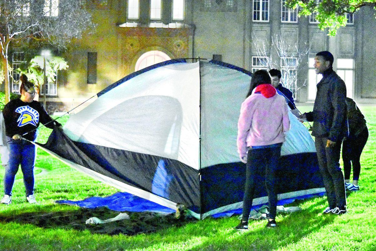  Sociology junior Elsa Salgado (left) and sociology sophomore Jermaine Bradley (right) help other members of the Student Homeless Alliance set up tents Thursday night. Christian Trujano/Spartan Daily.