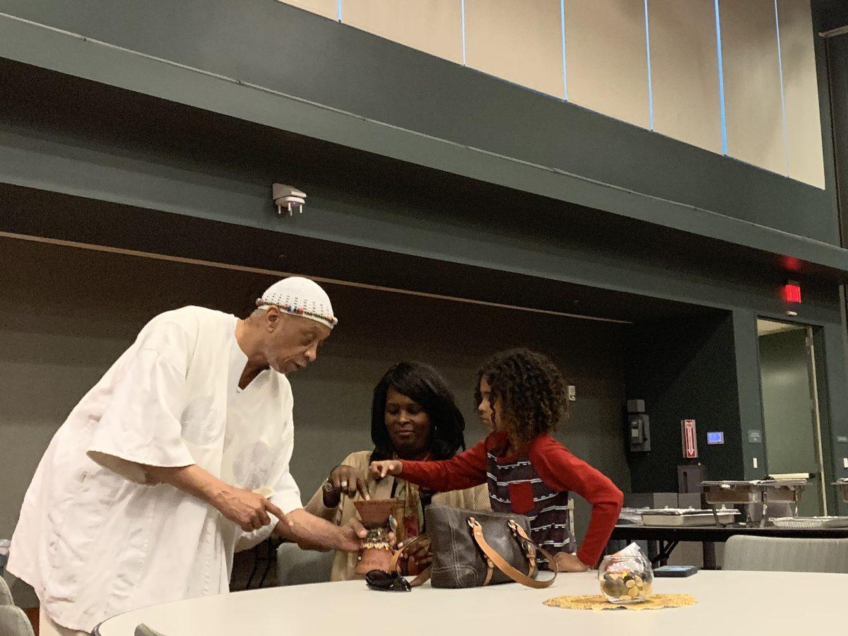 Performer Claude Ferguson speaks with Sonja Daniels, associate vice president of campus life, and her son Maxwell during the libations ceremony for the 2020 SJSU Black History Month Celebration Monday night. Diana Avila | Spartan Daily