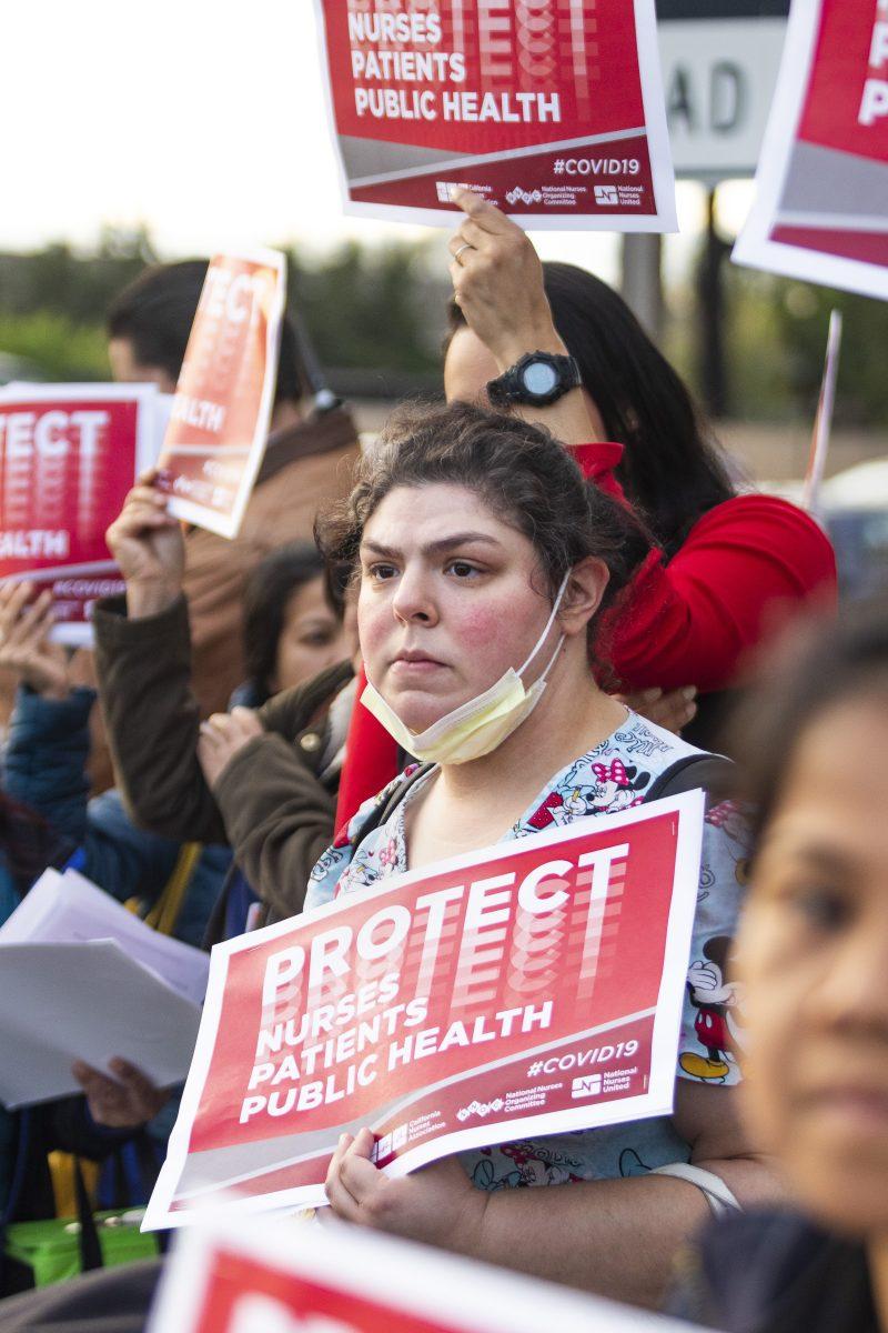 Janette Aguirre, a Santa Clara Kaiser Permanente floor nurse holds a sign protesting the CDC&#8217;s new recommendations for medical staff, which some believe raise the risk of new coronavirus infections among medical staff. Gia Pham/Spartan Daily