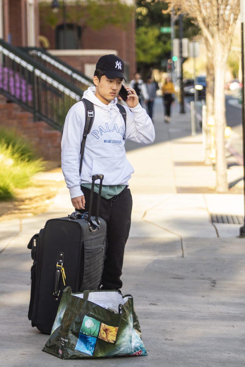 Aerospace engineering freshman Sean Kim stands on East San Salvador Street with his luggage. He was waiting for a ride home from his parents Tuesday. Gia Pham/Spartan Daily