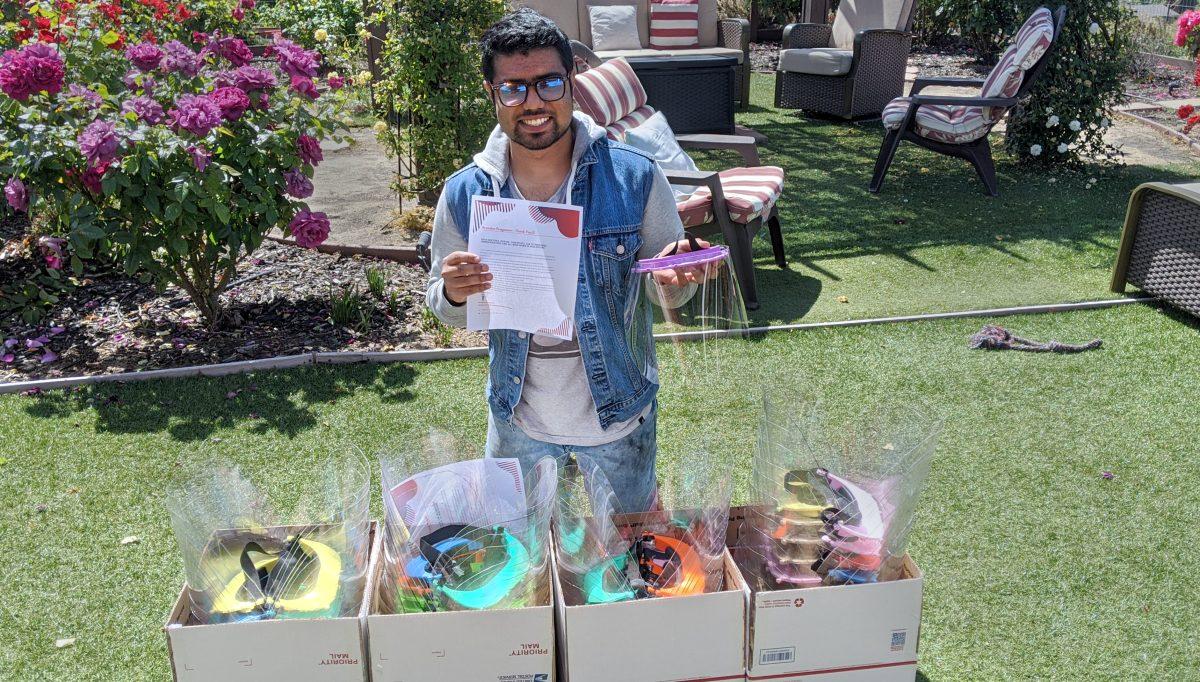 Industrial design junior Brenden Pragasam poses with 3D-printed face shields outside his home. He plans to donate them to the Stanford Medical Center. Courtesy of Brenden Pragasam
