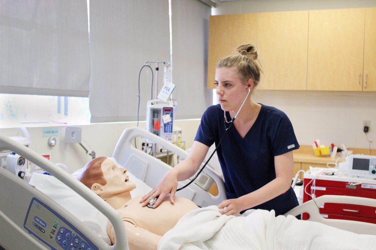Nursing senior Hamilton Shoecraft checks the heartbeat of her robotic patient in the Simulation Center during her junior year on April 18, 2019. Cora Wilson/Spartan Daily Archives