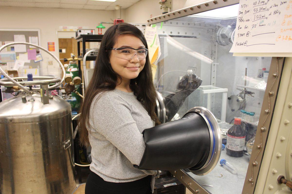  Chemical engineering senior Jocelyn Valenzuela works with a sample of modified nanodiamonds inside a glovebox because they are highly sensitive to oxygen and water. Photo courtesy of Jocelyn Valenzuela.