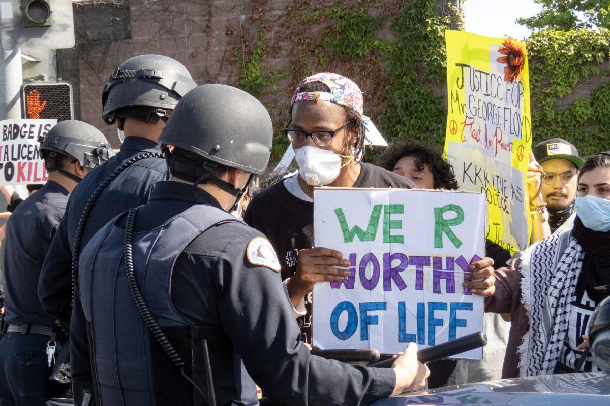 A protester argues with a San Jose police officer who told other protesters, &#8220;You guys make me laugh,&#8221; at the Highway 101 and 30th Street offramp Friday afternoon. Christian Trujano/Spartan Daily.