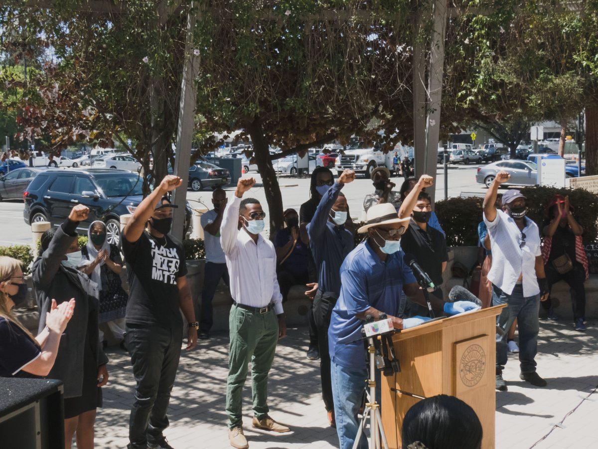 Speakers at the Santa Clara County Board of Supervisors news conference to declare racism as a public health crisis raise their hands in solidarity with the Black Lives Matter movement Monday. Christian Trujano/Spartan Daily