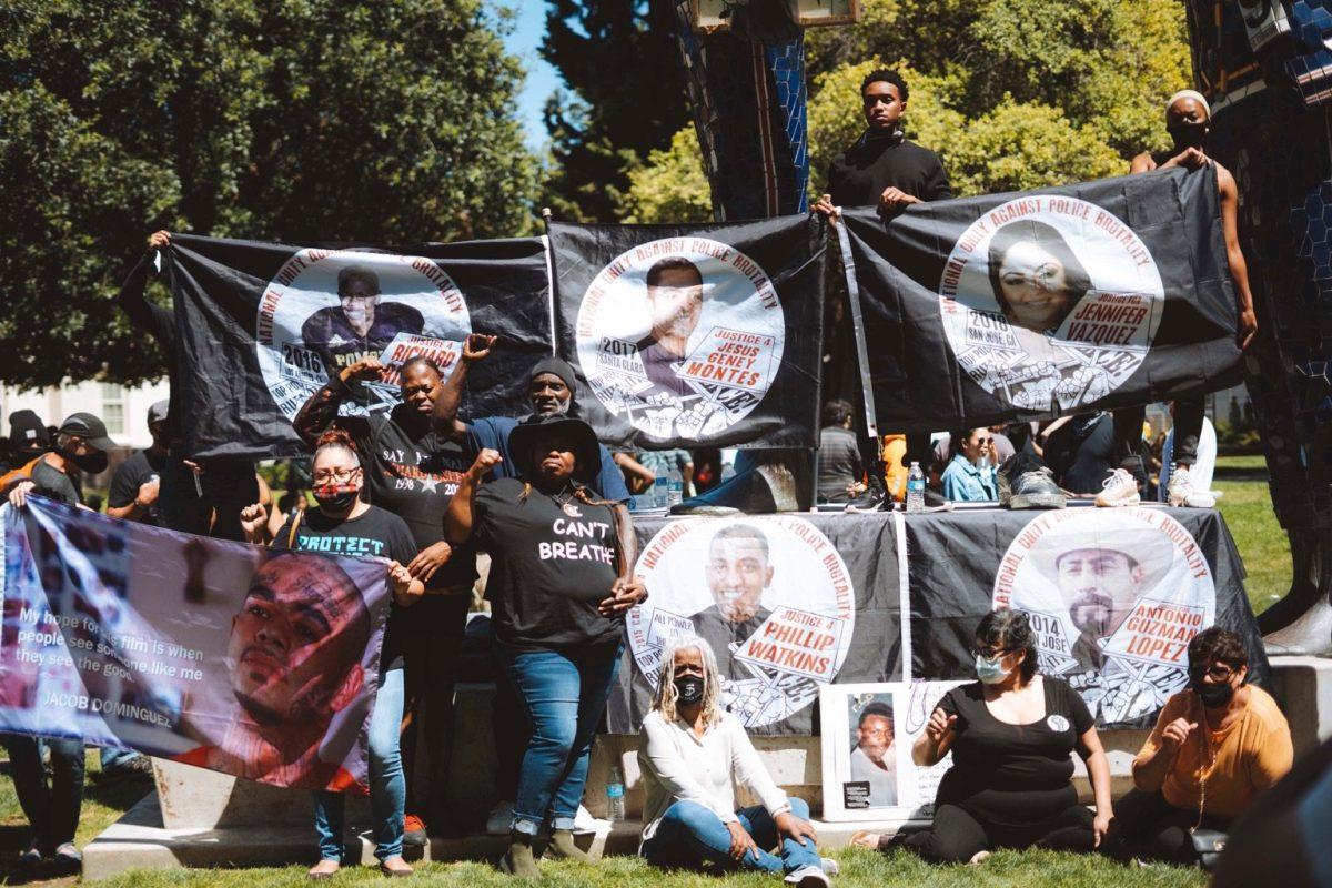 Several mothers of victims killed by police brutality pose with the banners of their children on Saturday. Jesus Tellitud/ Spartan Daily 