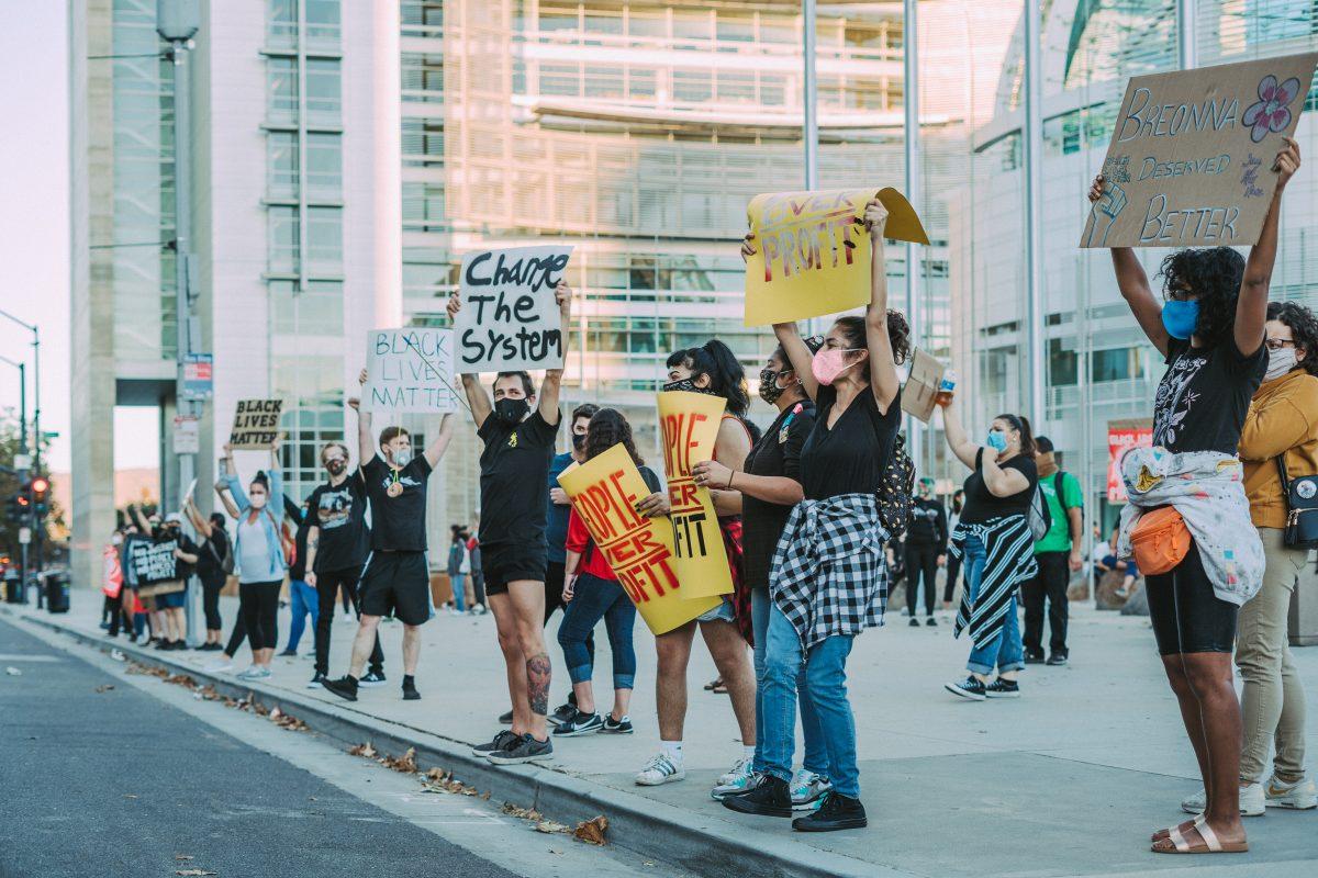 Protesters hold a 5-minute moment of silence for Breonna Taylor around the "Just 4 Breonna" mural Wednesday night in front of San Jose City Hall after collaborating on it. Blue Nguyen/ Spartan Daily.