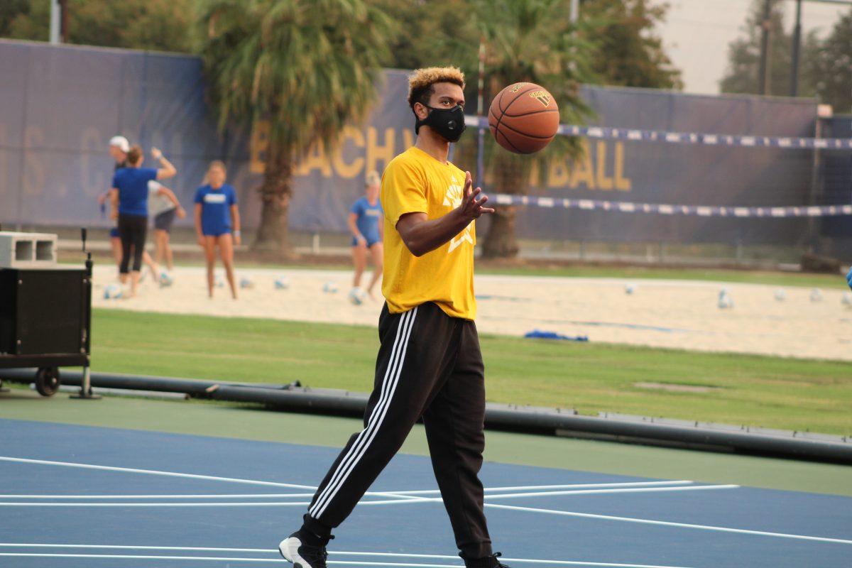 Junior guard Trey Smith tosses a basketball in the air during an offensive drill at practice on Sept. 9 at the South Campus outdoor basketball courts. Photo courtesy of SJSU Athletics.