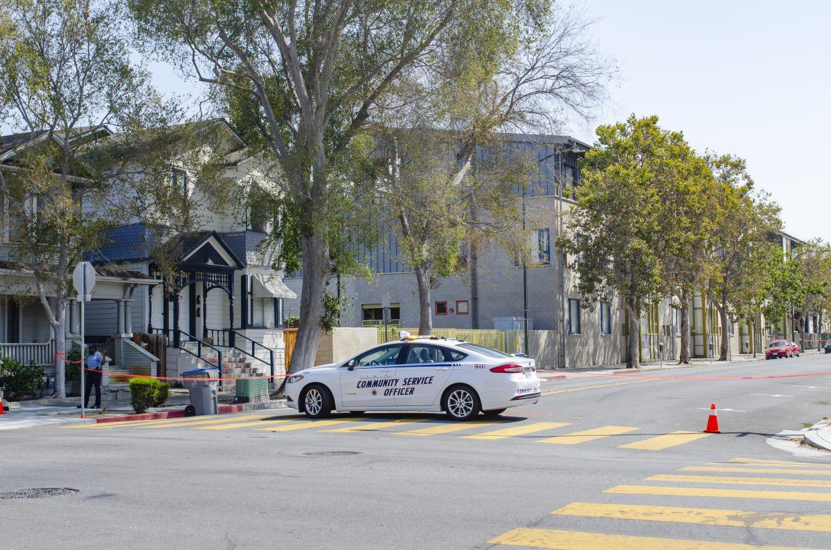 A community service patrol officer closes off a scene with tape at the corner of North Sixth and East St. John streets on Sept. 21.