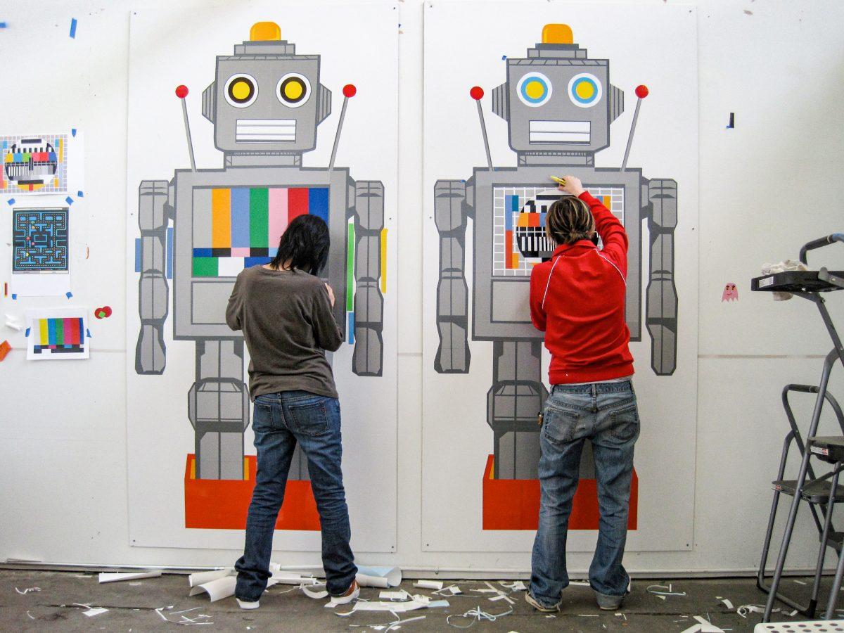 Paula Pereira (left) and Pernilla Andersson (right) hand cut vinyl for their art piece &#8220;We are Humans.&#8221; 