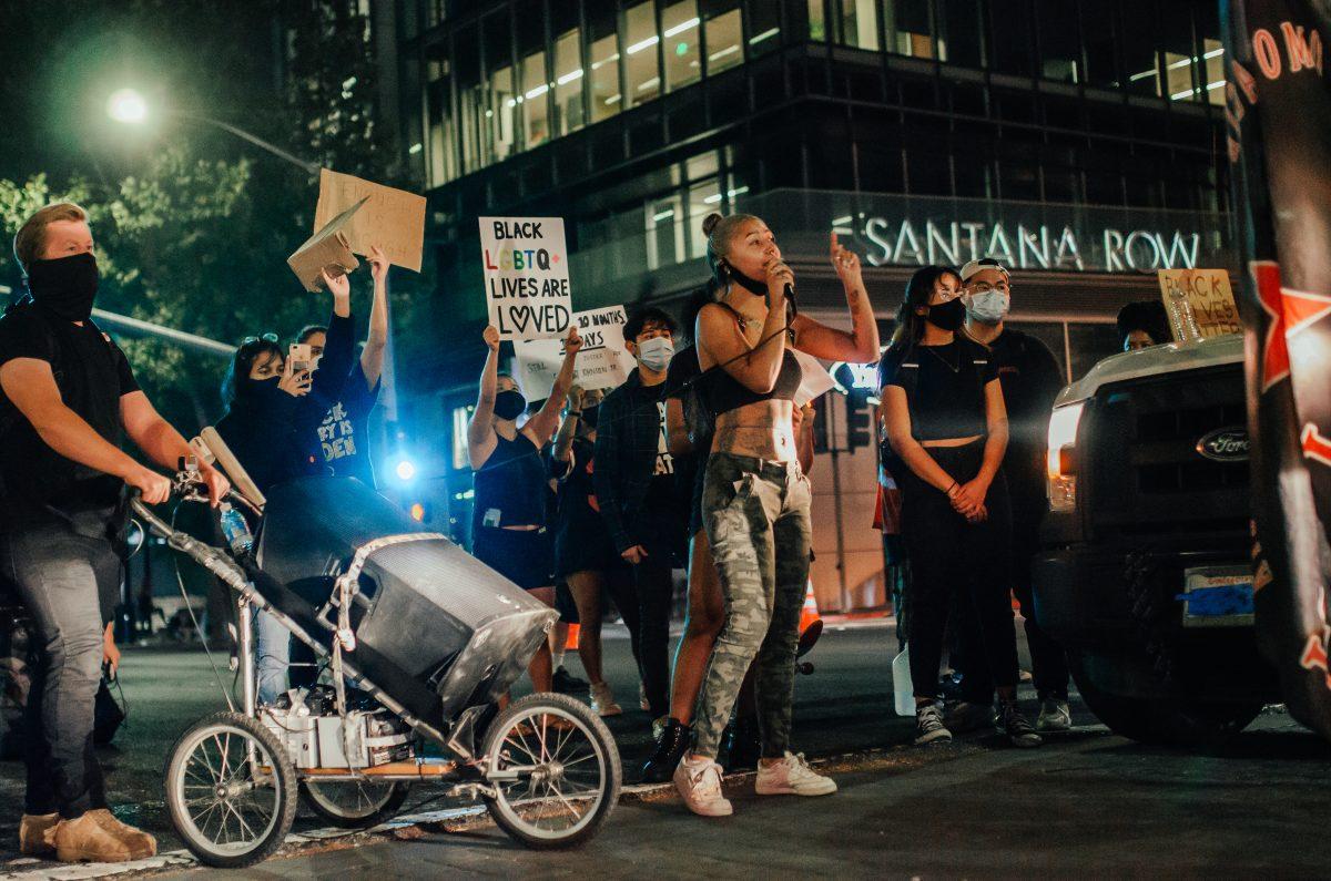 Protester blocks Santana Row and Stevens Creek Boulevard intersection, calling people in the car to come out and join the protest with them, taken on Oct. 2 Blue Nguyen/Spartan Daily. 