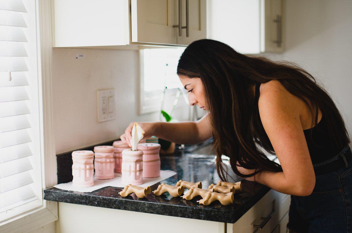 Elma Avakian tends to a candle mold in the shape of a woman&#8217;s body. Photo by Blue Nguyen.