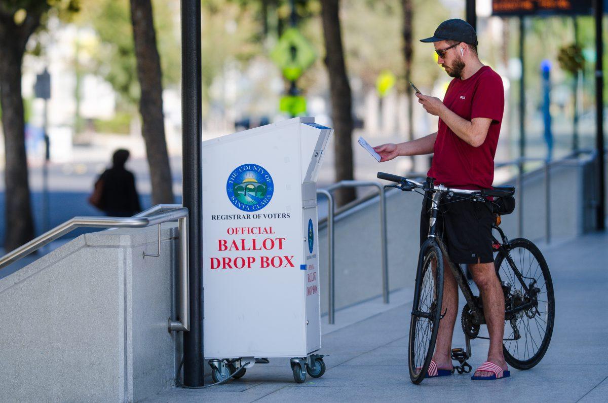 Joey Tierney, a San Jose State environmental studies alumnus, takes a photo of his ballot before dropping it into a ballot box on campus Wednesday. Blue Nguyen/Spartan Daily
