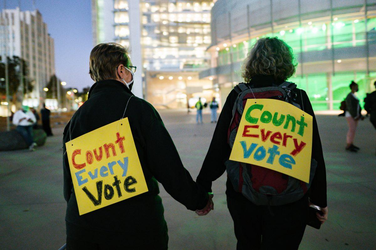 Deborah (left) and Carole Jett (right), married 10 years, hold hands and check in on other participants before the vigil portion of the &#8220;Count All Votes&#8221; rally begins. Blue Nguyen/ Spartan Daily.