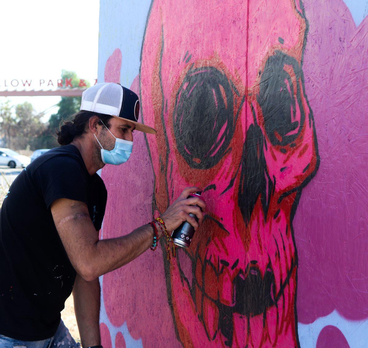 Roberto Romo, a Chicano artist and high school teacher, paints a skull to celebrate D&#237;a de los Muertos at a market on Saturday. Photo by Isalia Gallo.