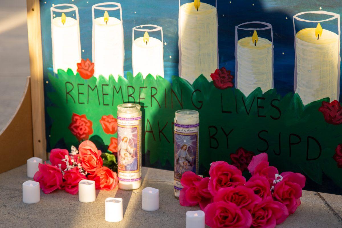 Flowers and candles surround a mural dedicated to the lives of 50 people killed by police over the last 20 years I Photo by Yami Sun