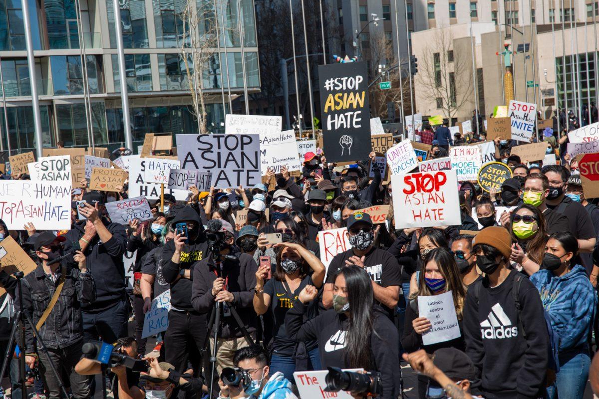 Demonstrators hold signs and listen to city leaders and community members speak Sunday at San Jose City Hall