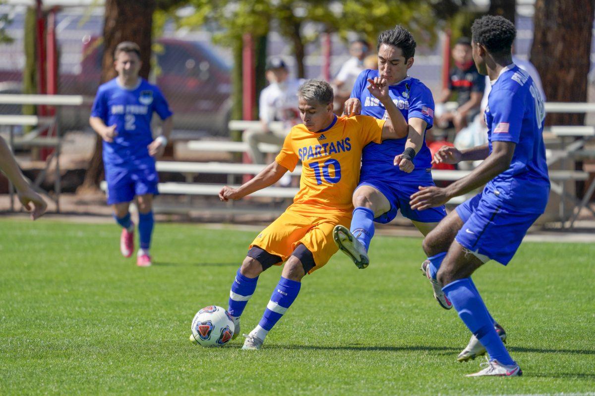 Midfielder Willy Miranda dribbles the ball past two defenders.