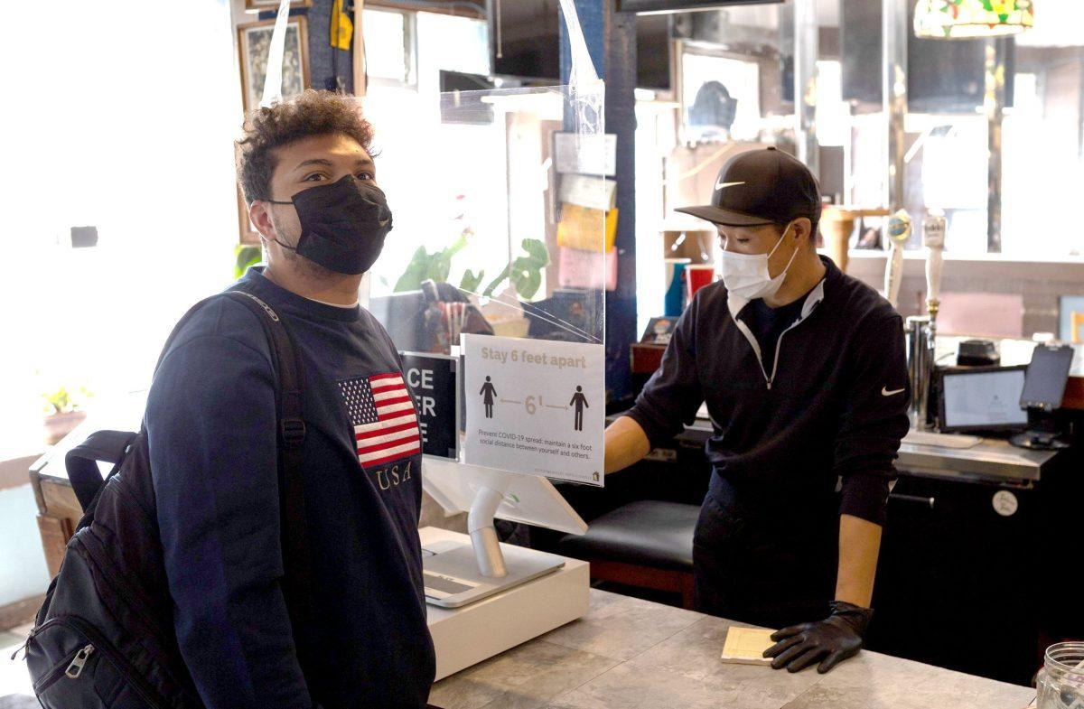 Sophomore business marketing student Jalen Allen examines the menu with Peanuts owner Joseph Chang Yann Lapnet | Spartan Daily