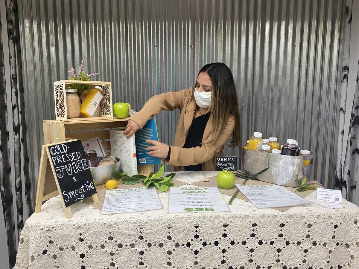 Andrea Tovar organizes her juice stand stand at the Community Day event hosted by the nonprofit Stories for Solidarity. Madilynne Medina | spartan daily