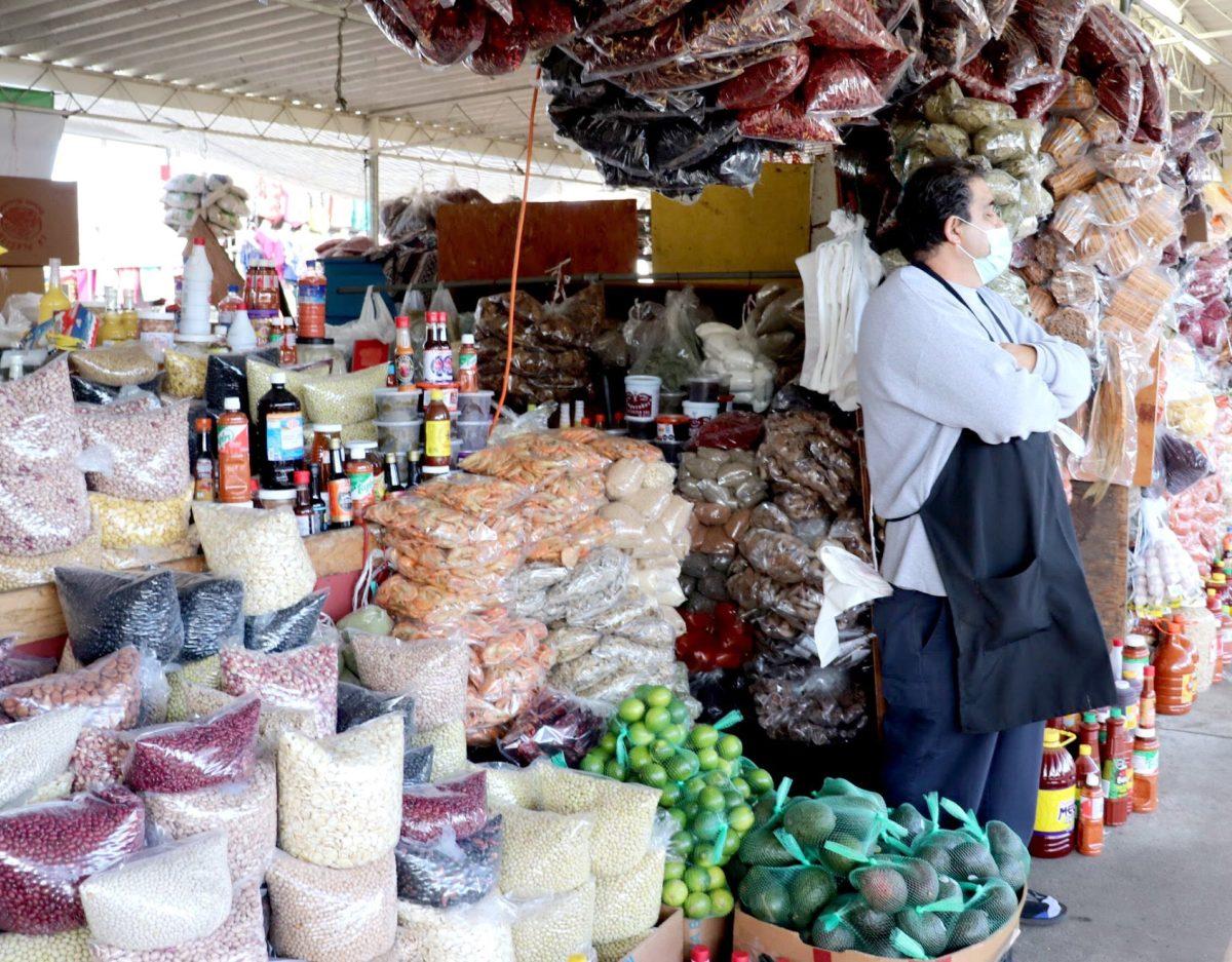 A market vendor stands in front of various dried ingredients and spices, including dried chiles, beans, and cinnamon sticks at his San Jose Flea Market stall on March 19. Photo by Jovanna Olivares