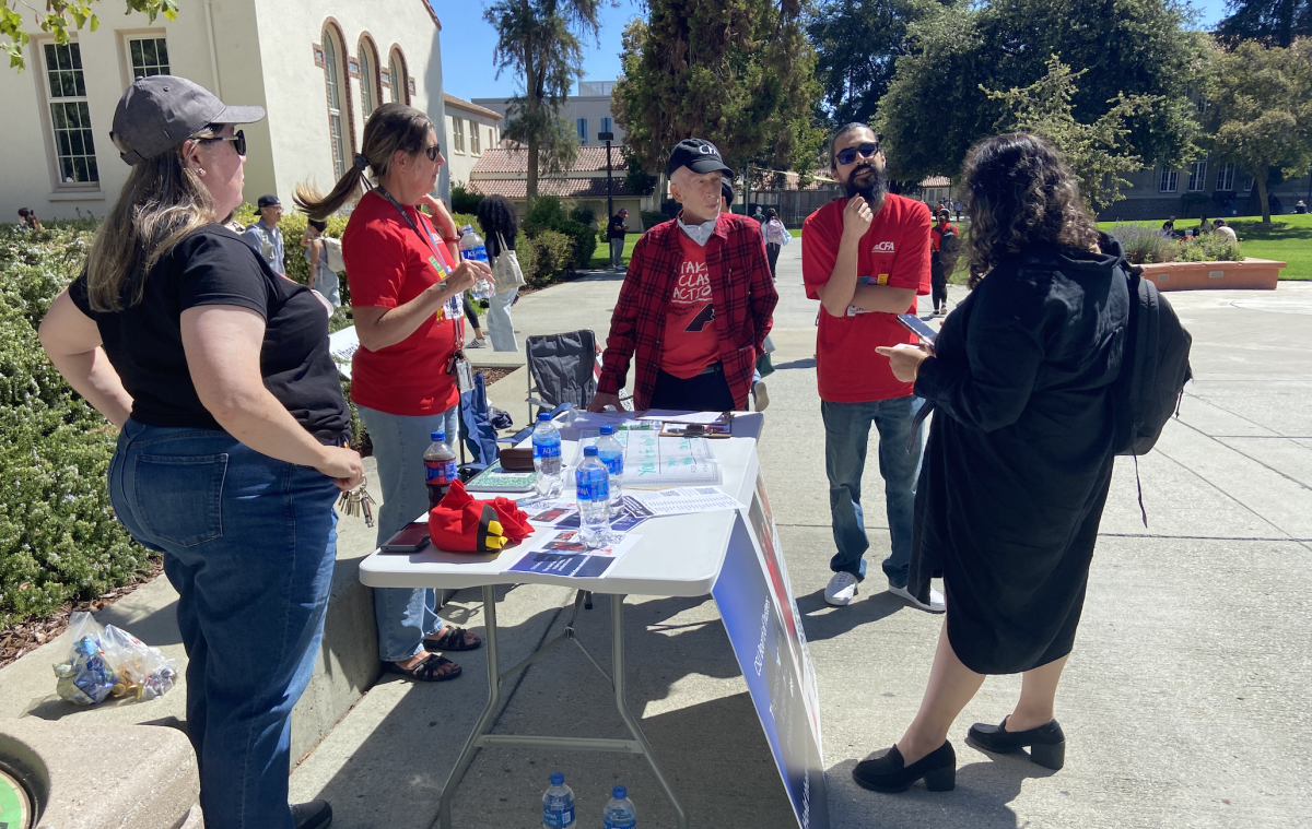 San Jose State chapter members of the California Faculty Association talk to SJSU student Muskan Parashar in front of Clark Hall on Tuesday afternoon. Bryanna Bartlett | Spartan Daily