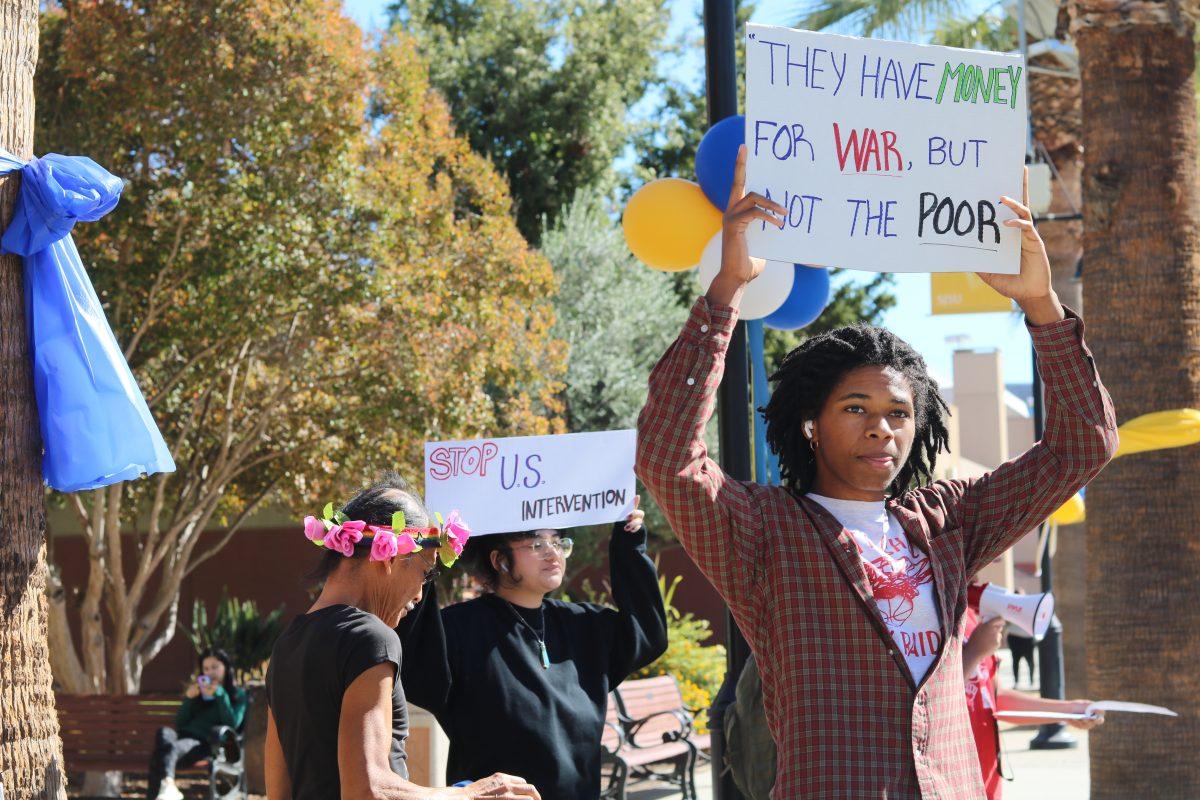 Students for a Democratic Society member holds up a sign during a protest on Seventh Street Plaza Monday afternoon. Shruthi Lakshmanan | Spartan Daily