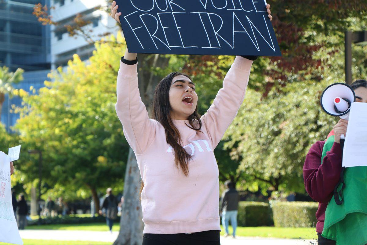 Persia Mozaffari, the Persian Student Association vice president of recruitment and San Jose State student, holds up a sign that says, &#8220;Amplify our voice free Iran&#8221; as she marches through campus Monday afternoon to increase students&#8217; awareness.