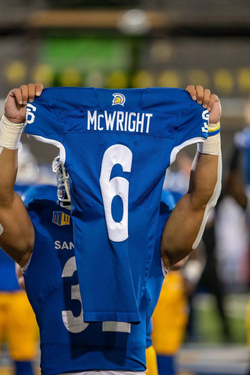 SJSU running back Kairee Robinson holds up Camdan McWright's jersey on the field before the Spartans' game at CEFCU stadium on Saturday night.