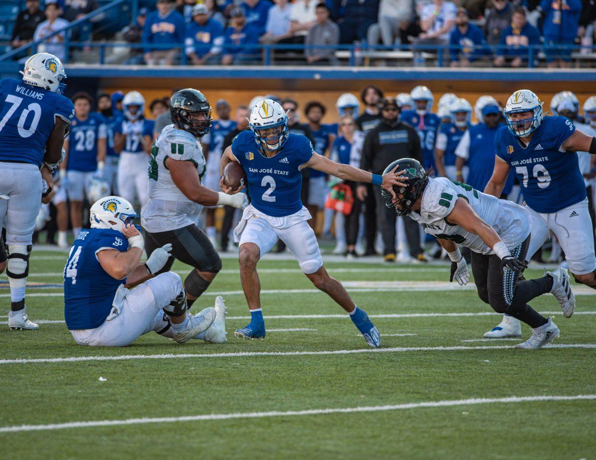 SJSU junior quarterback Chevan Cordeiro stiff arms a defender during Saturday's game against Hawai'i at CEFCU Stadium