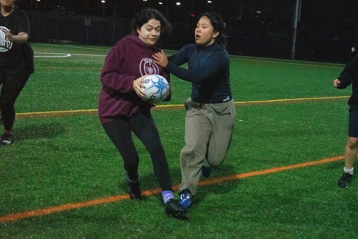Math freshman, Thanh Tang, tackles a teammate during a practice game at Spartan Field on Tuesday.