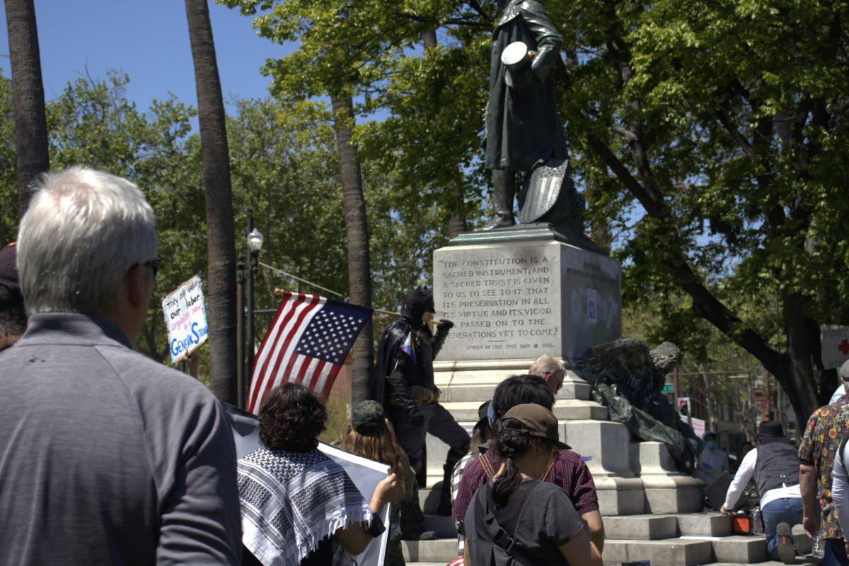 Protesters gather near the statue of President William McKinley at St. James Park in San Jos&#233; on Saturday afternoon with signs against the current presidential administration.