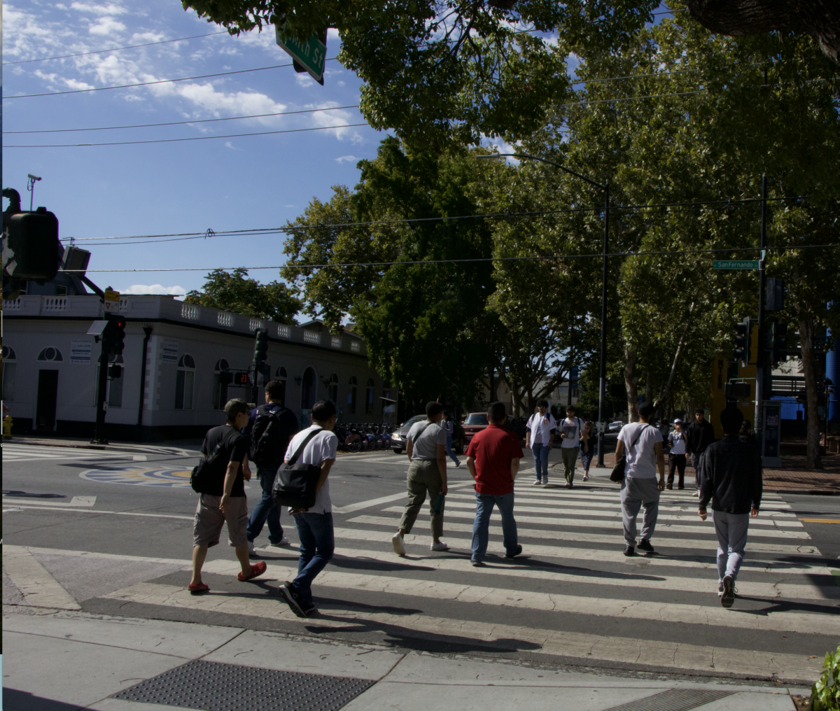 Students walk to and from the San José State campus across East San Fernando Street near the South Parking Garage.