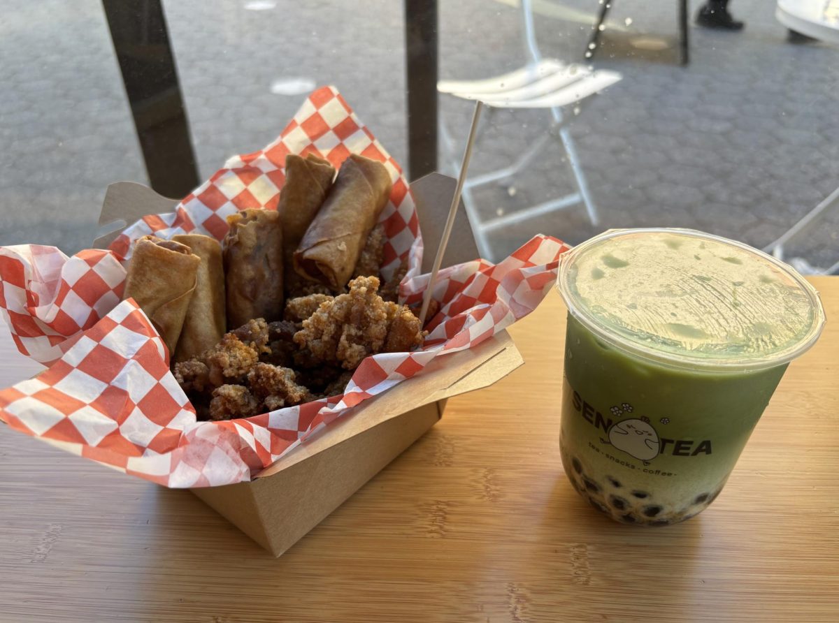 Freshly fried popcorn chicken and egg rolls sit along side an iced honey boba matcha latte on an outdoor table near the SenTea resturant in Paseo de San Antonio.