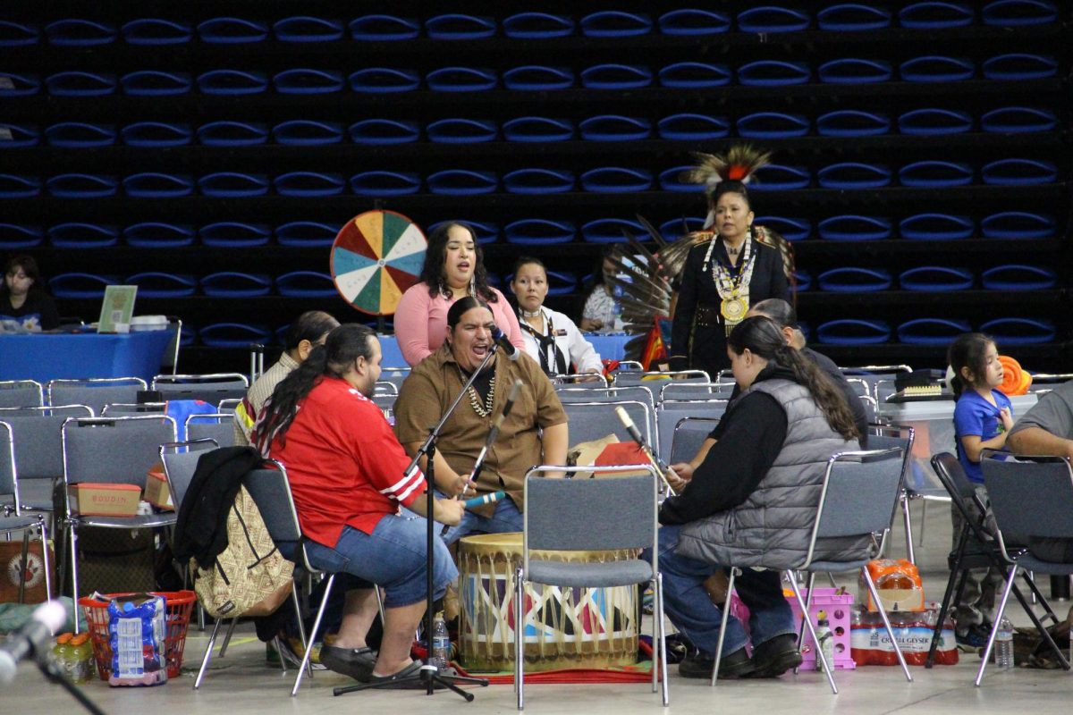 Red Hoop Singers, a powwow drum group, sing songs with the drums for the performers.