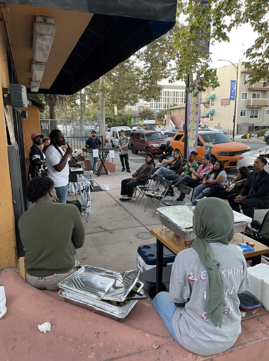 Lou Dimes, the president of B.L.A.C.K. Outreach San José and founder of Feed the Block, welcomes the group to the "Last Sundays" open-mic event on Sunday evening.