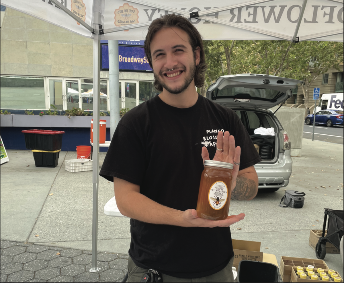 Gabriel Diaz, an SJSU third-year environmental science student, holds a jar of locally made honey.