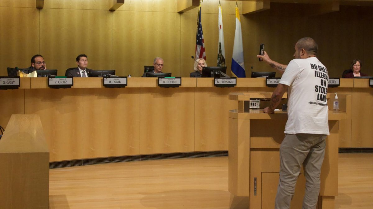 Misrayn Mendoza, organizing manager at Amigos de Guadalupe Center for Justice & Empowerment
presents a photo of a masked ICE agent to San José City councilmembers at Tuesday’s council meeting.