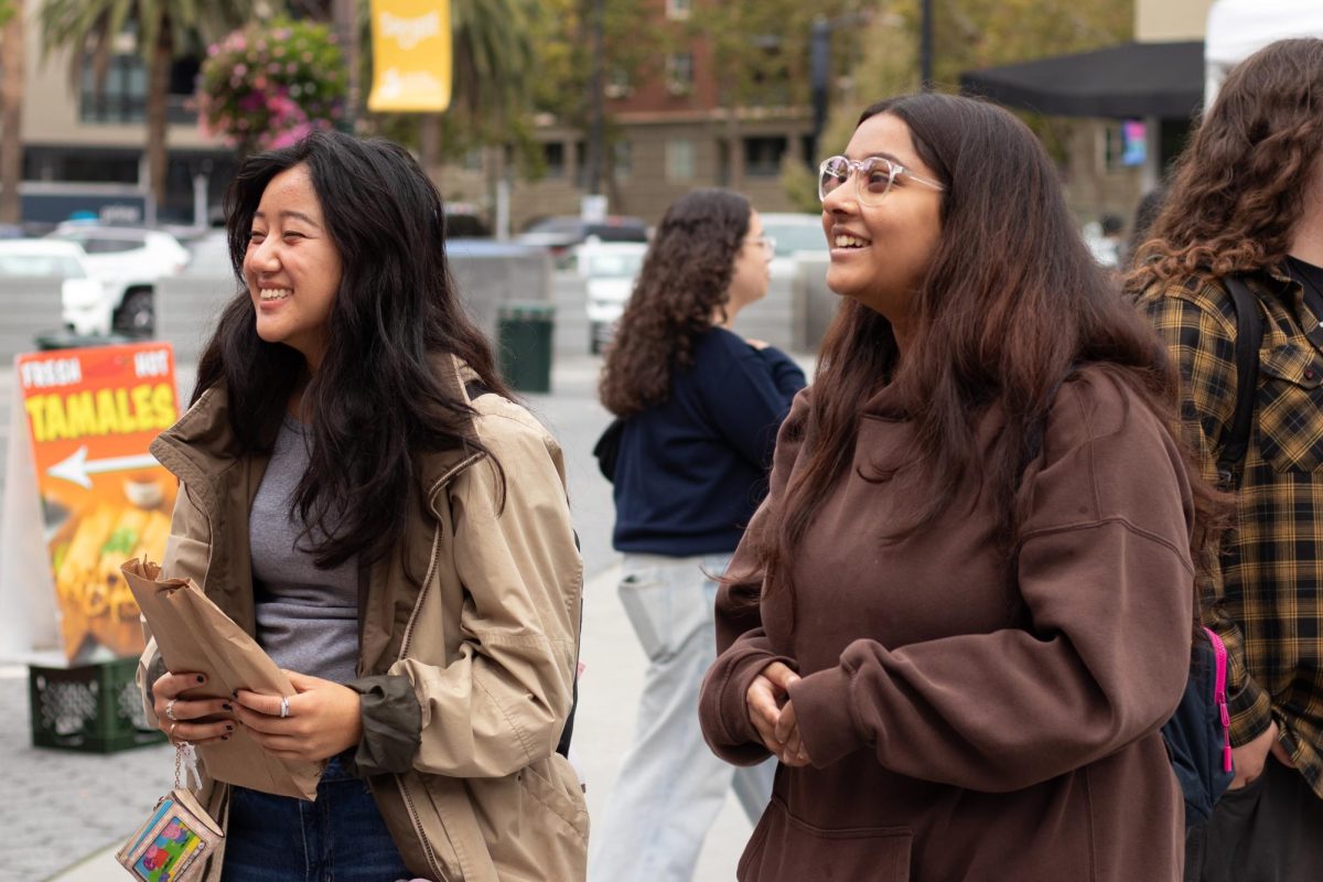 Kaylin Rongong and Aafreen Ahsan, third-year psychology students, line up at Thai Street Food’s booth at the market.