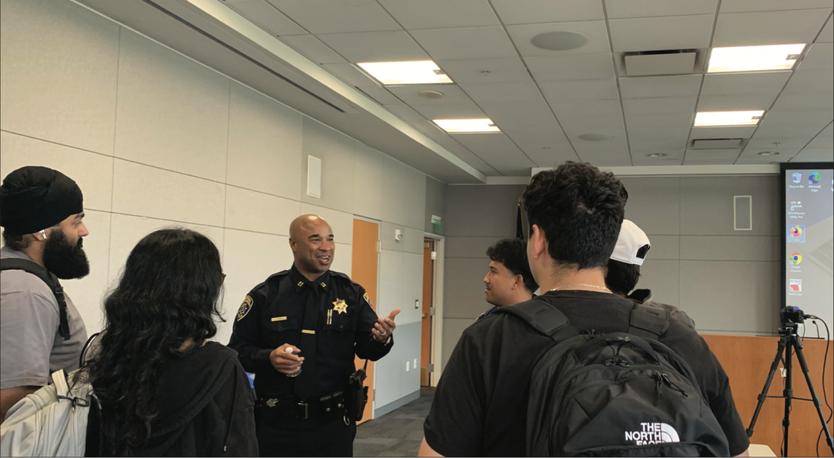 San José State University Police Captain of Operations Management Jermaine Thomas speaks with school of management students on Tuesday inside the MLK Library.