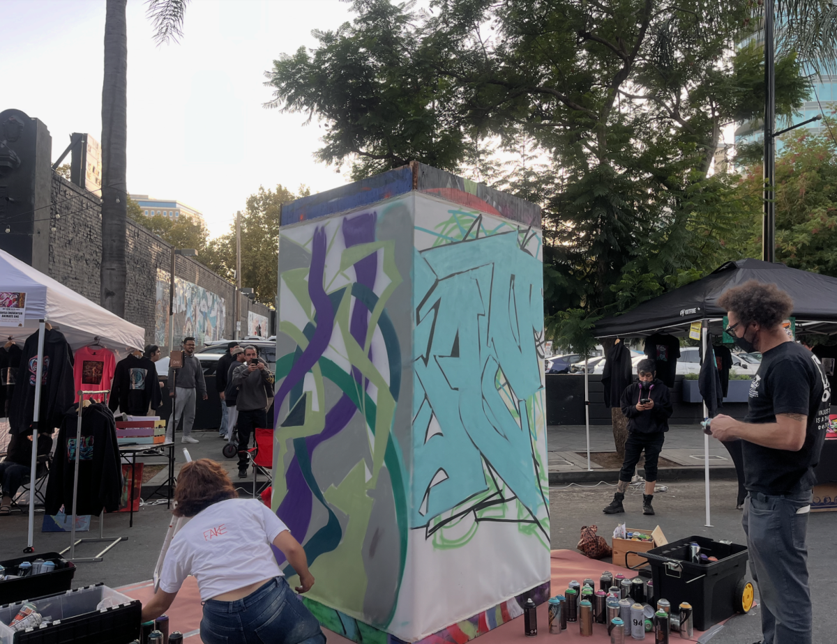 Graffiti artists live paint a wooden pillar at the ArtWalk SJ First Friday near Miami Beach Club on South First Street before opening day.