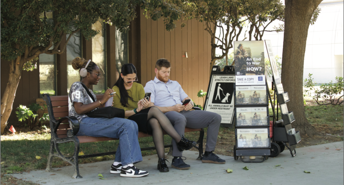 Jehovah’s Witnesses sit at a bench next to a religious literature display near Tower Lawn on Tuesday afternoon on the SJSU campus.
