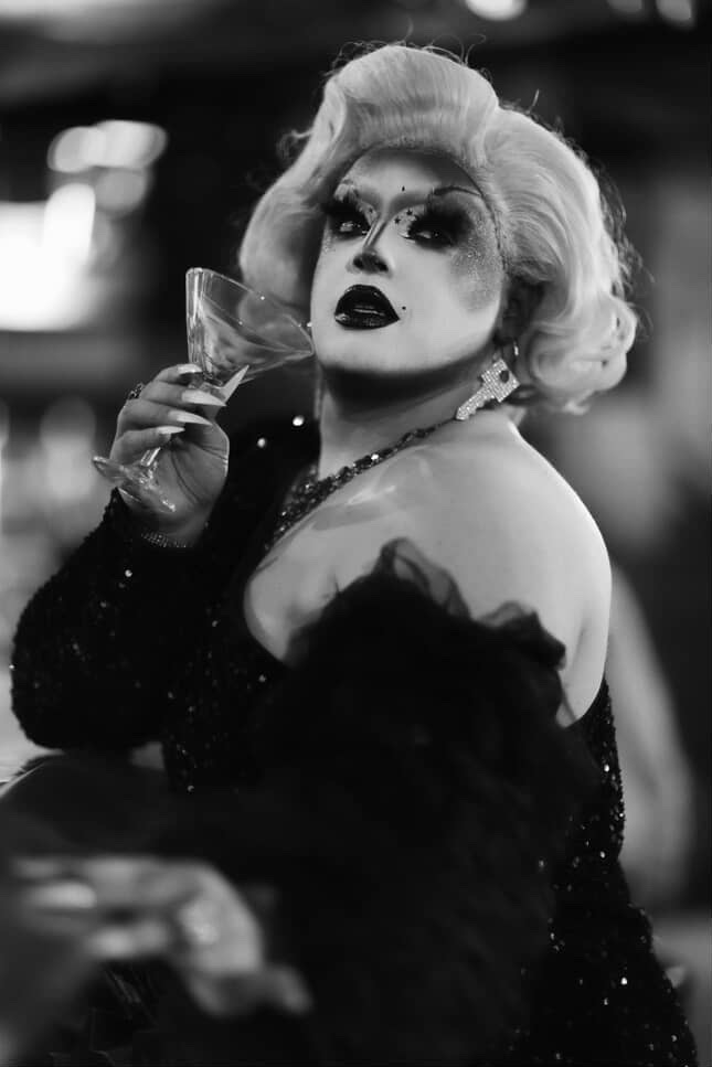 Catinni P. Vandon, drag performer in San José, poses seductively with a martini glass.