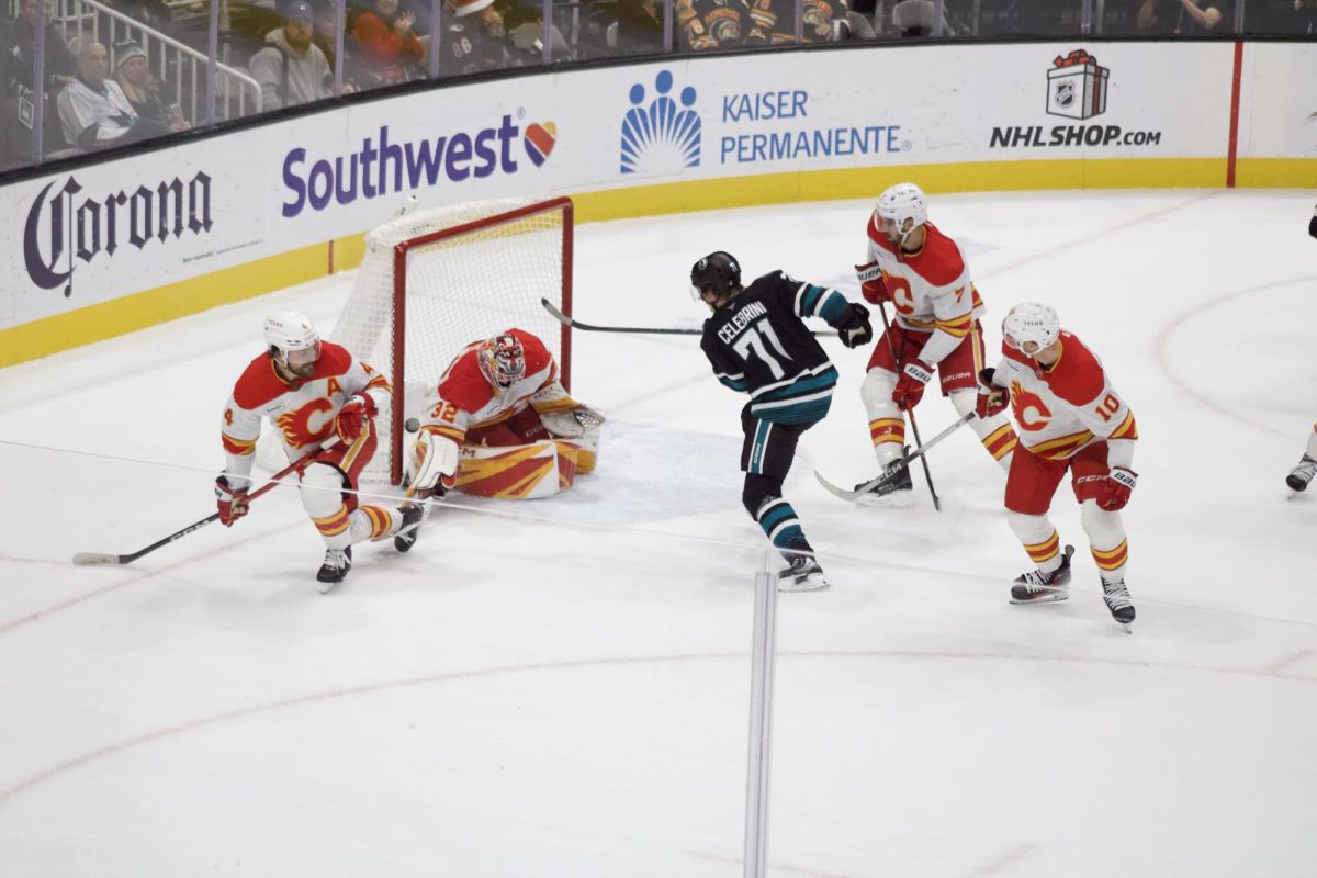 Sharks forward Macklin Celebrini finds an opening in the Calgary Flames' defense and takes a shot on goal. 