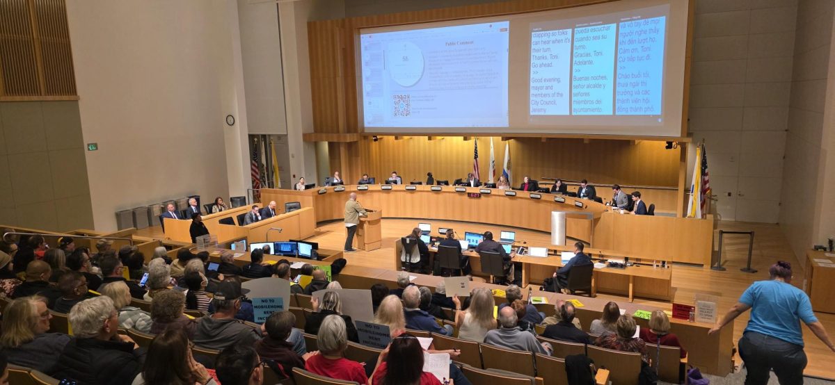 A San José resident speaks to city council about amendments to Title Five of the San José Municipal Code and Regulations for the Inclusionary Housing Ordinance at City Hall on Tuesday. Community members and protesters sit in the council chambers listening to public comments and awaiting a decision.
