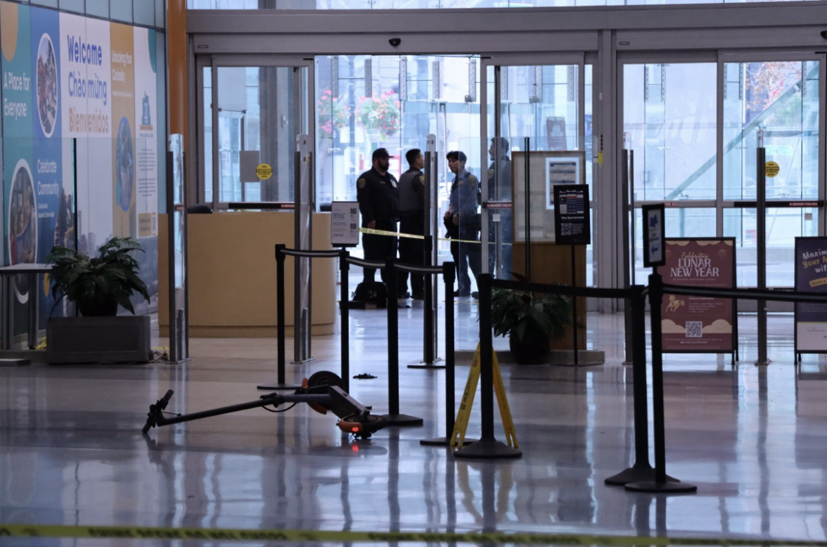 San José police and campus security  block off crime scene inside the Dr. Martin Luther King, Jr. Library, where a scooter and backpack are left on the ground from the incident.
