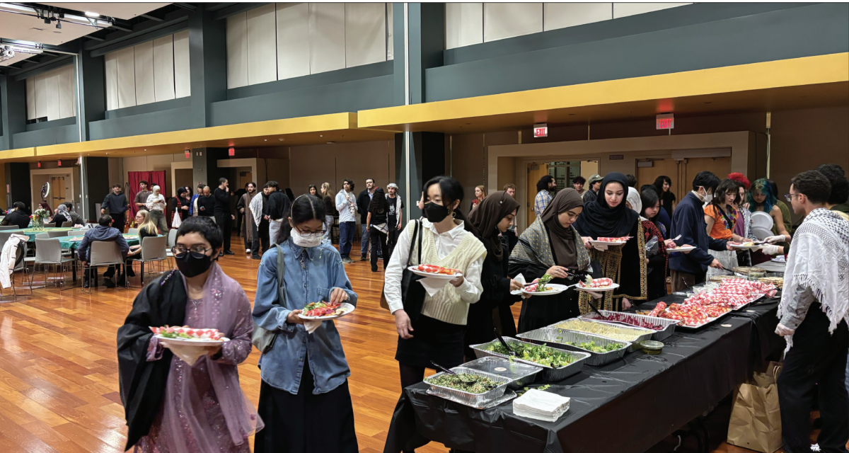 Students and attendees line up for dinner before performances from poets, muscians and dancers begin inside of the Student Union Ballroom. 